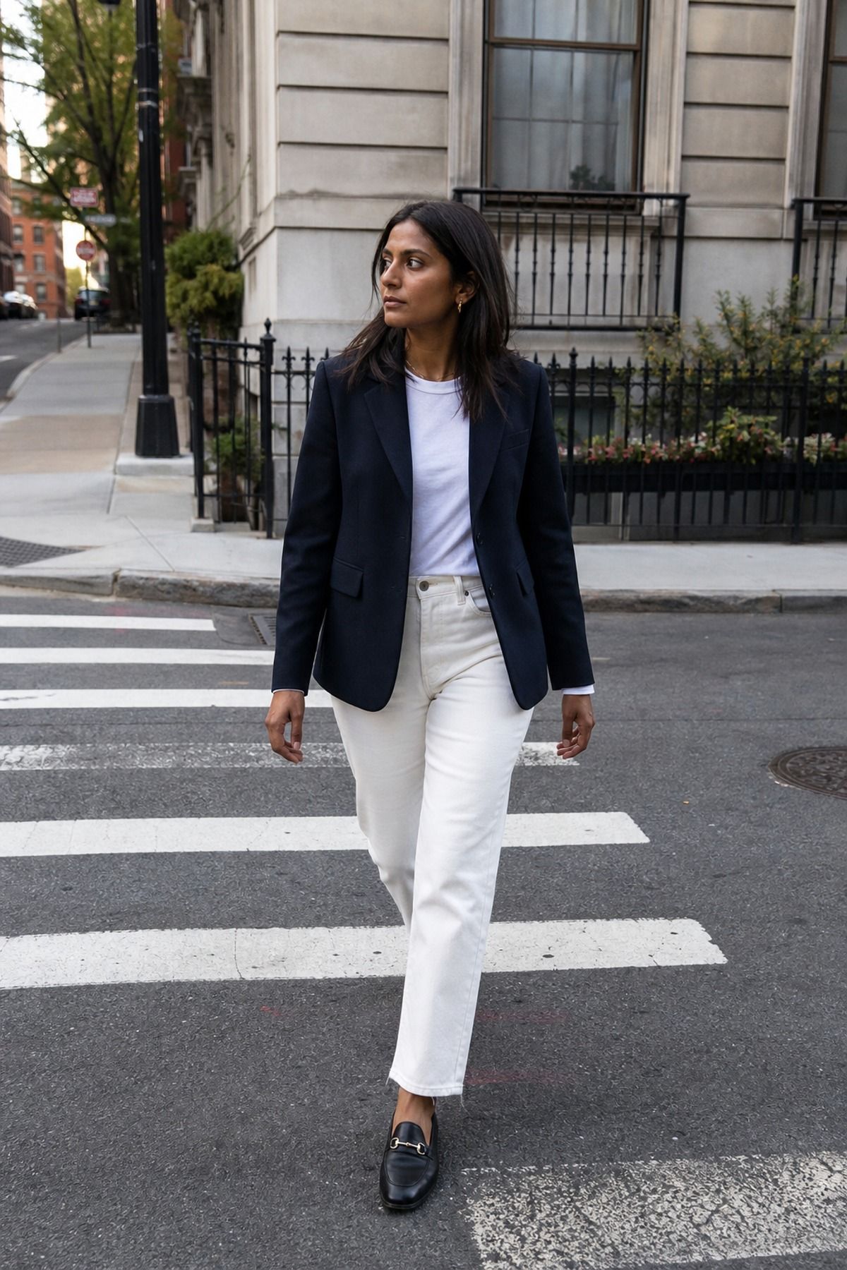Woman wearing a navy blazer with white jeans, a neutral outfit