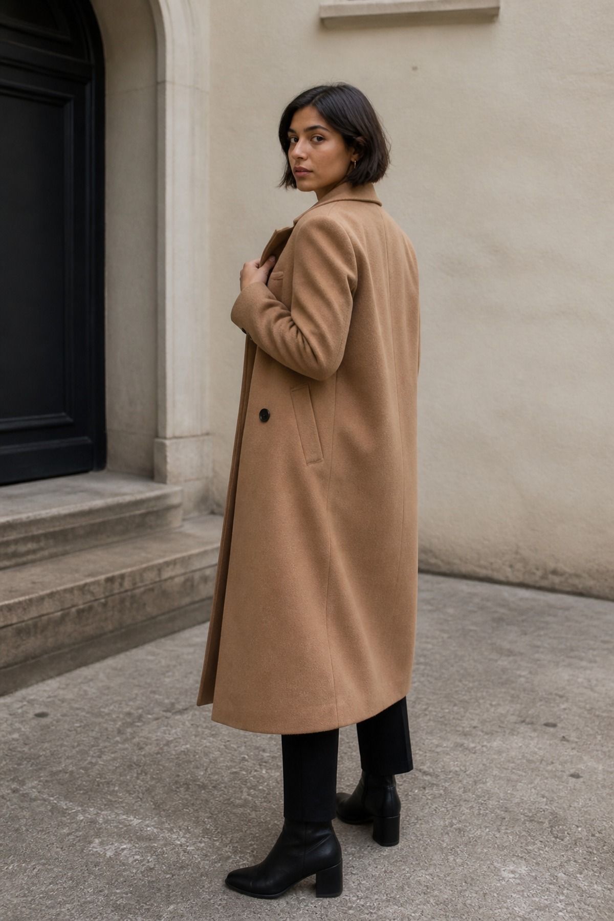 Woman wearing a camel coat with black basics, a neutral outfit