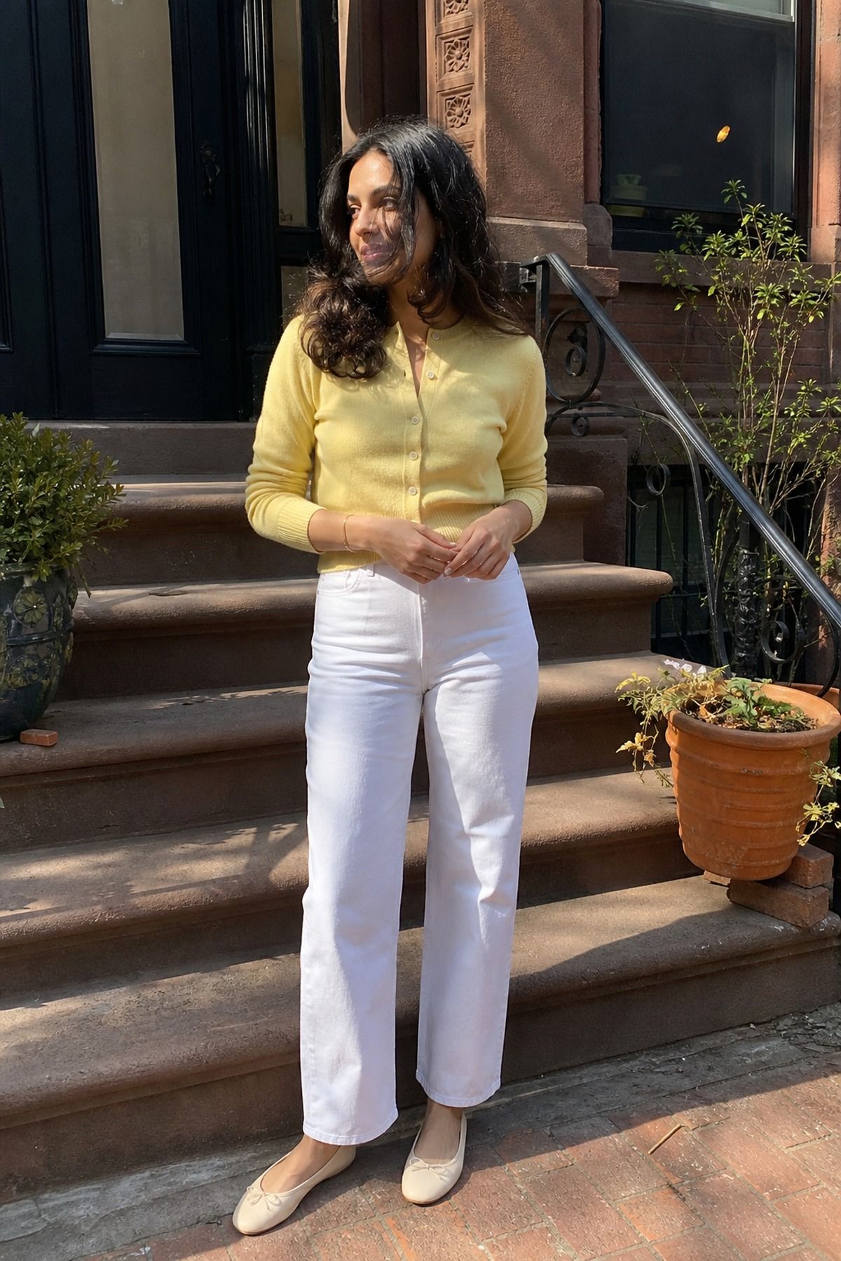 Woman wearing a butter yellow cardigan with white jeans, a pastel outfit