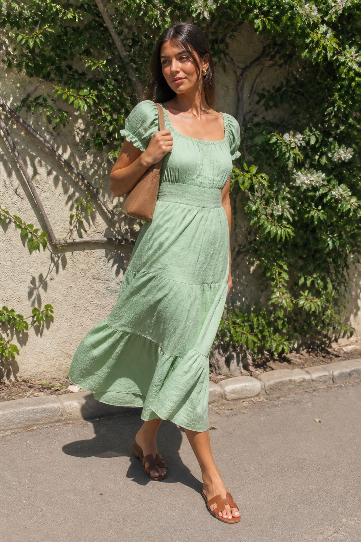 Woman wearing a mint dress with brown sandals, a pastel outfit