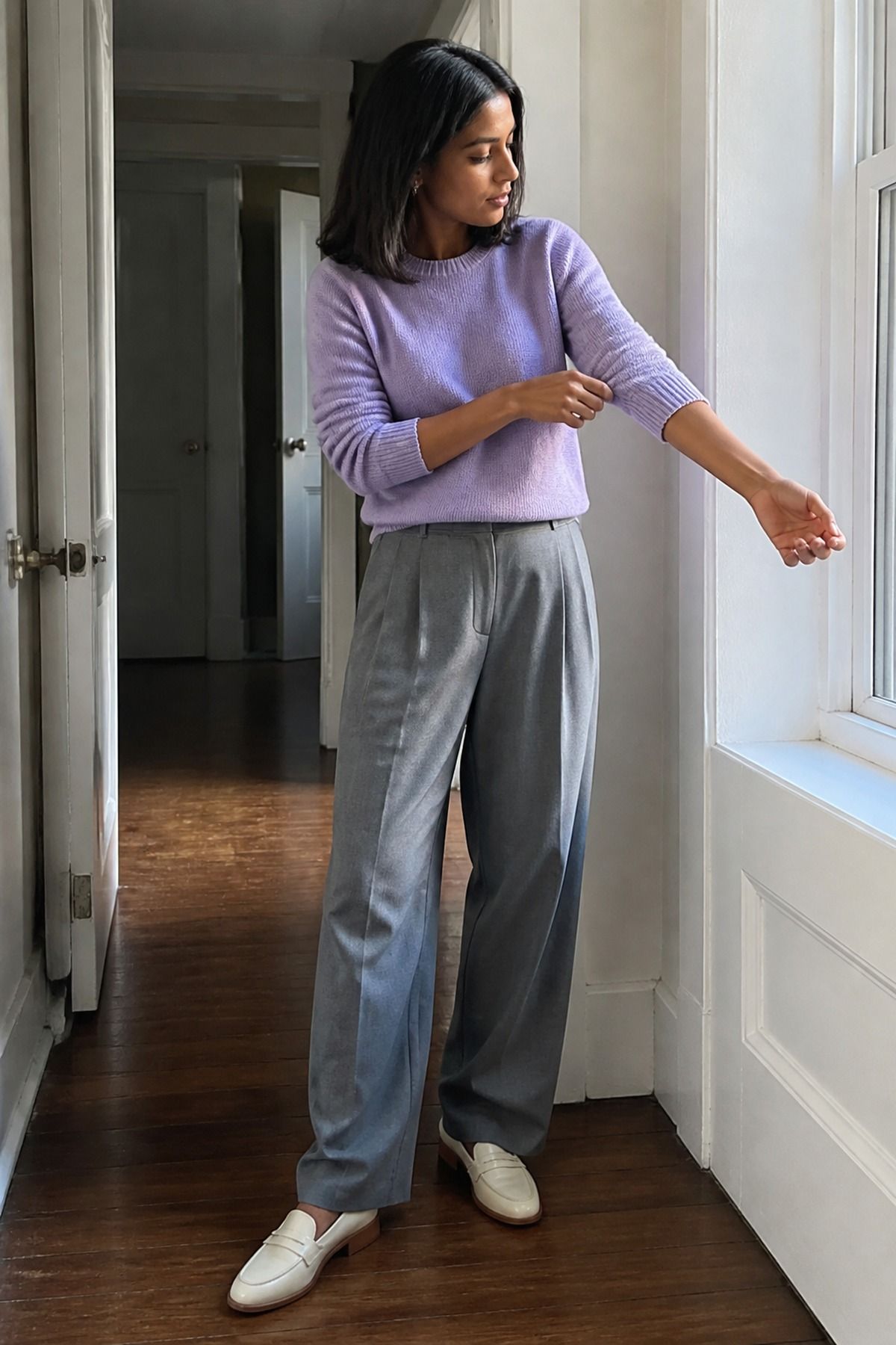 Woman wearing a lilac sweater with gray trousers, a pastel outfit
