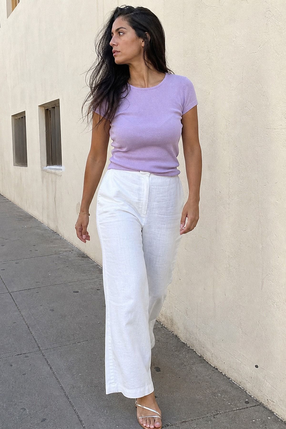 Woman wearing a lavender tee with white wide-leg pants, a pastel outfit