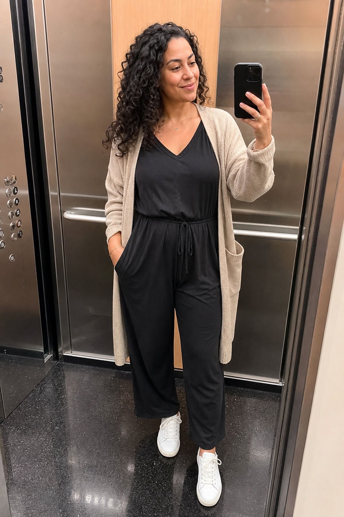 Woman wearing a nursing jumpsuit with a cardigan, a postpartum outfit