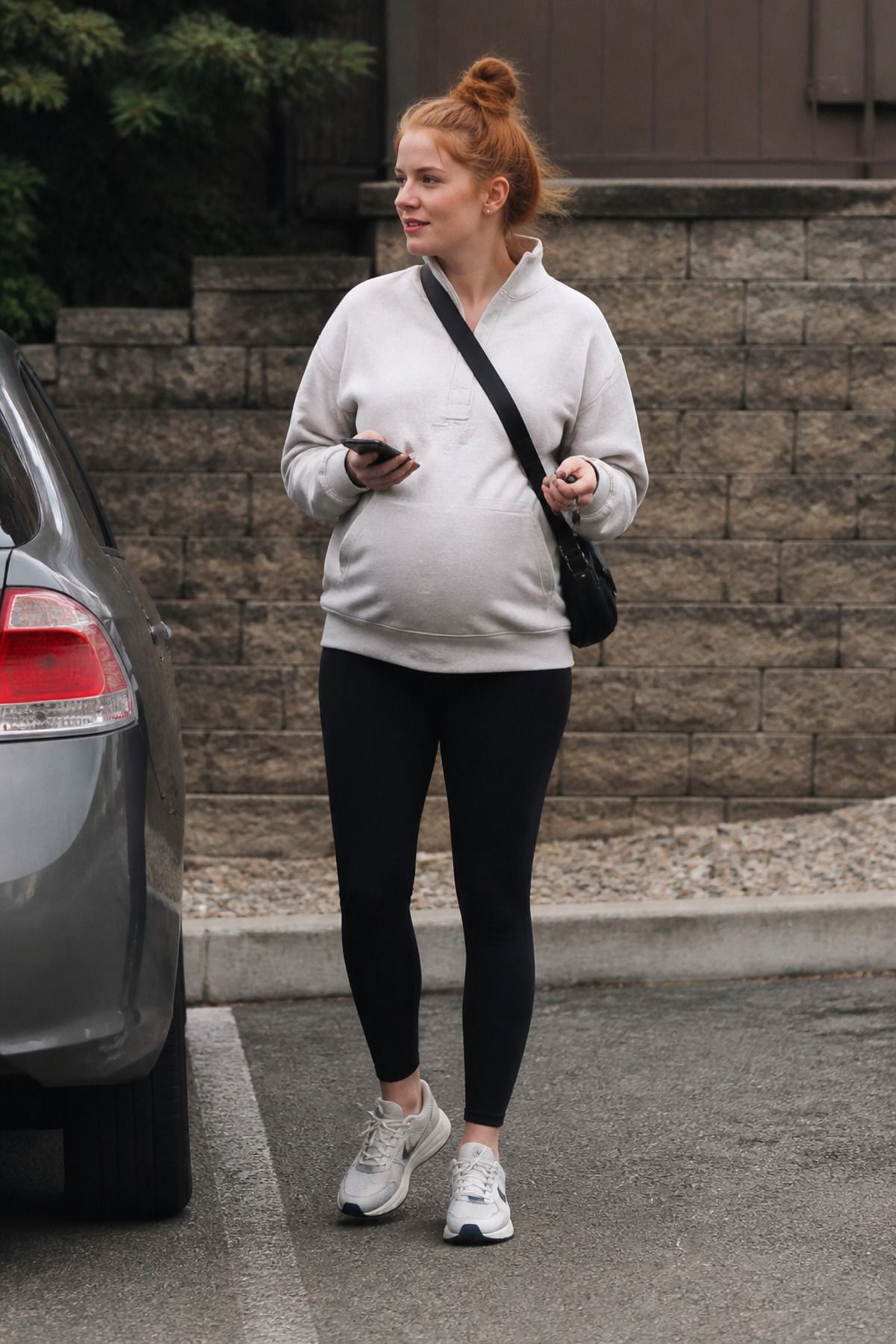 Woman wearing maternity leggings with a longline sweatshirt, a pregnancy casual outfit