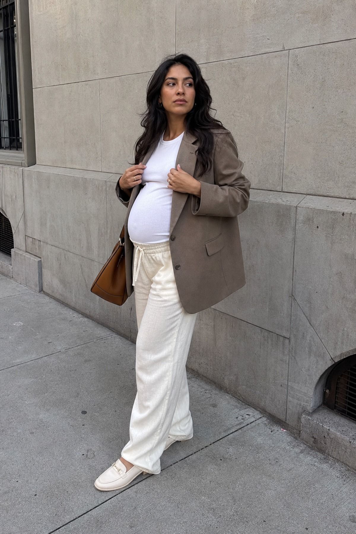 Woman wearing soft trousers with a bump tee and oversized blazer, a pregnancy casual outfit