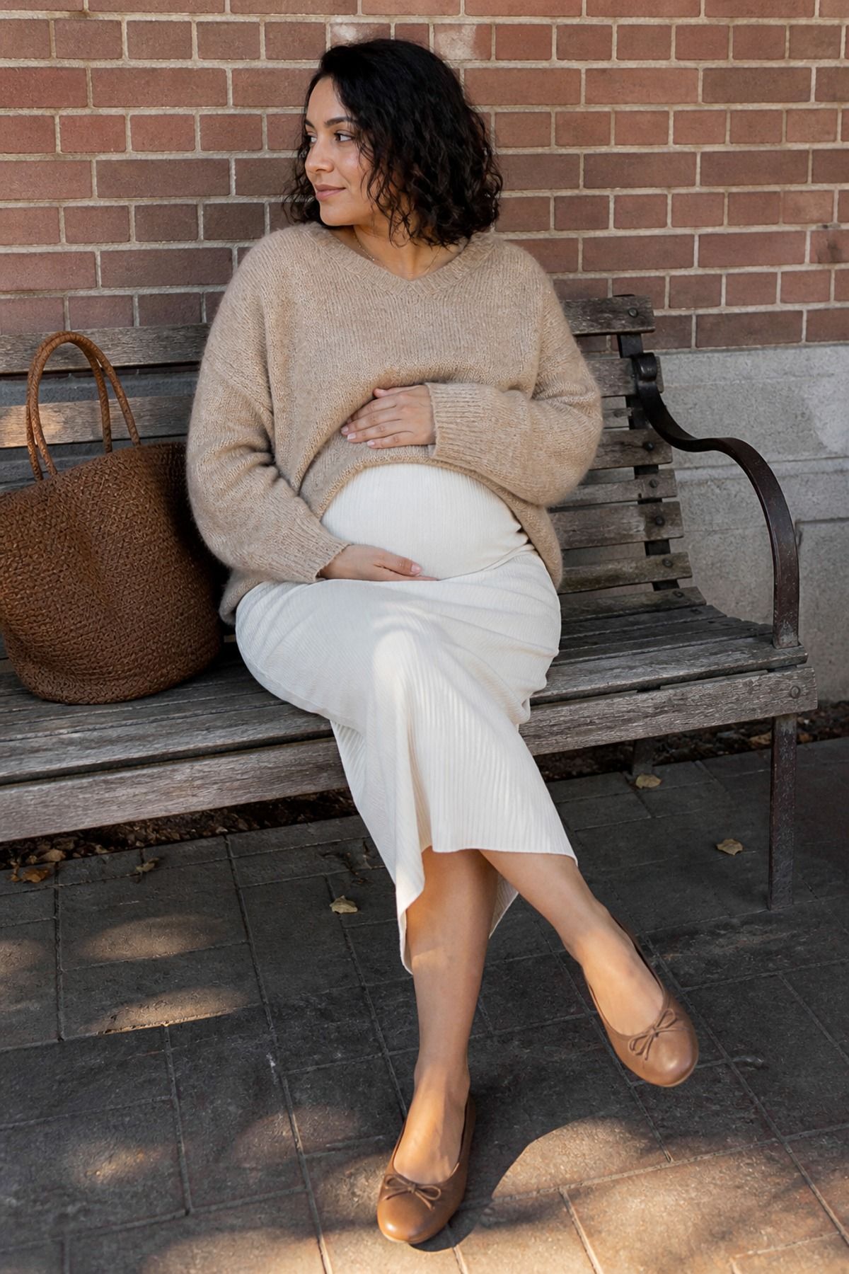 Woman wearing a pull-on skirt with an oversized sweater, a pregnancy casual outfit