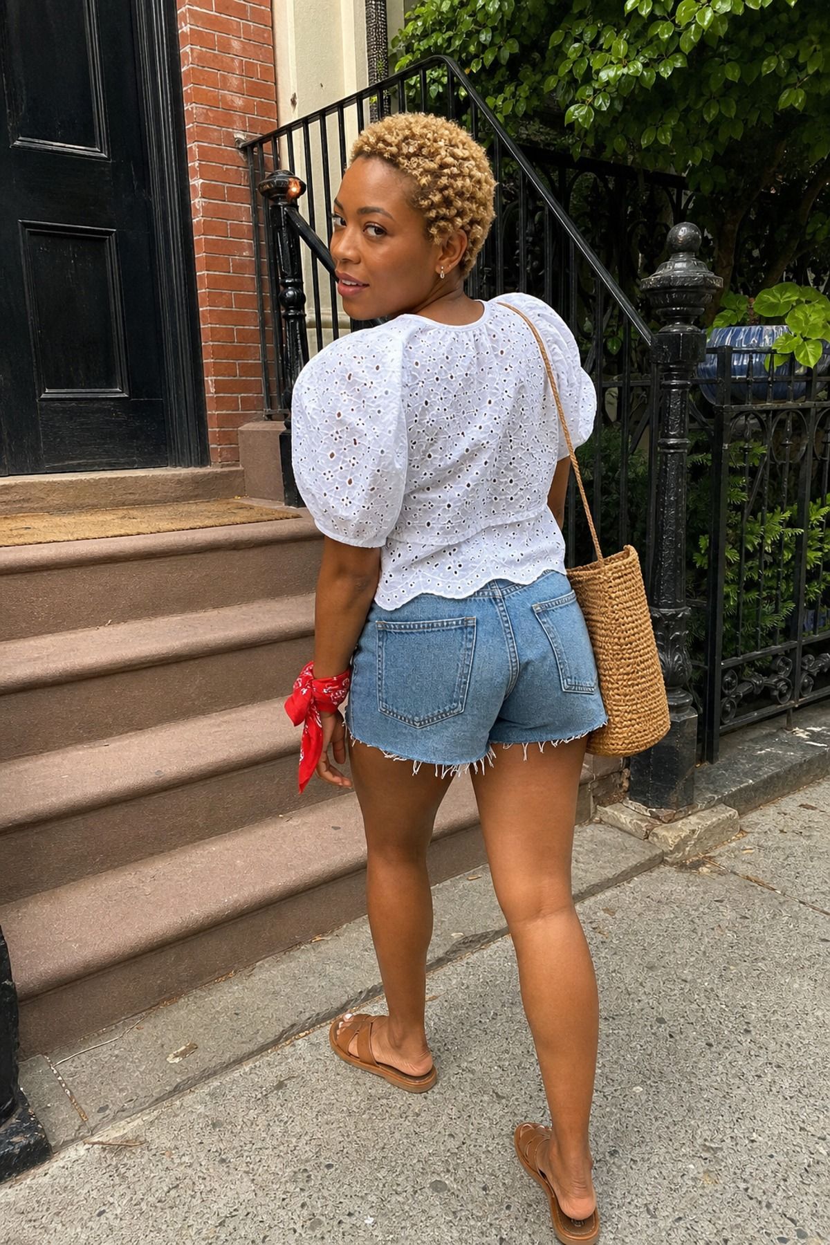 Woman wearing a white eyelet top with denim cutoffs, a Fourth of July outfit