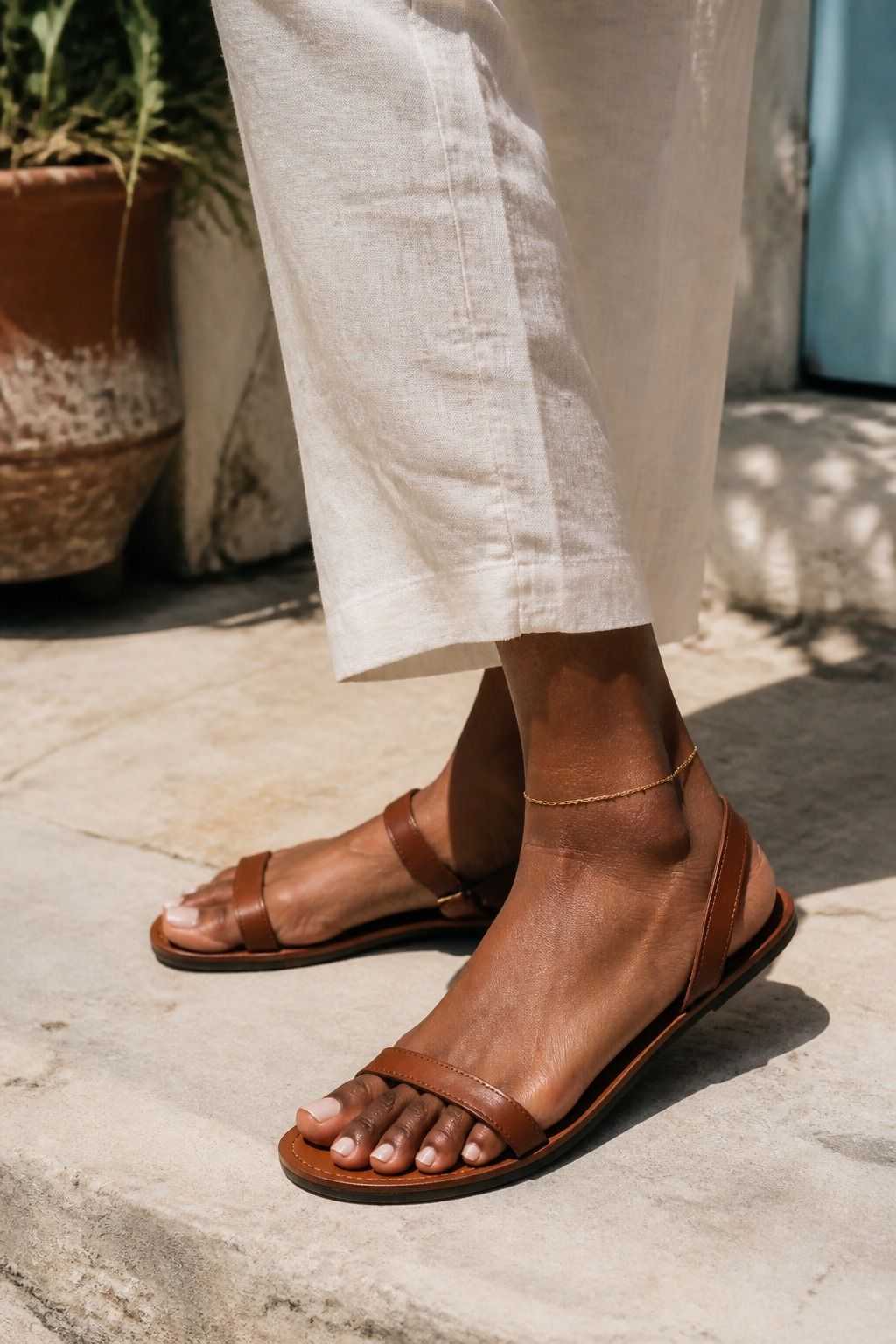 Woman wearing a delicate anklet with sandals and cropped linen pants