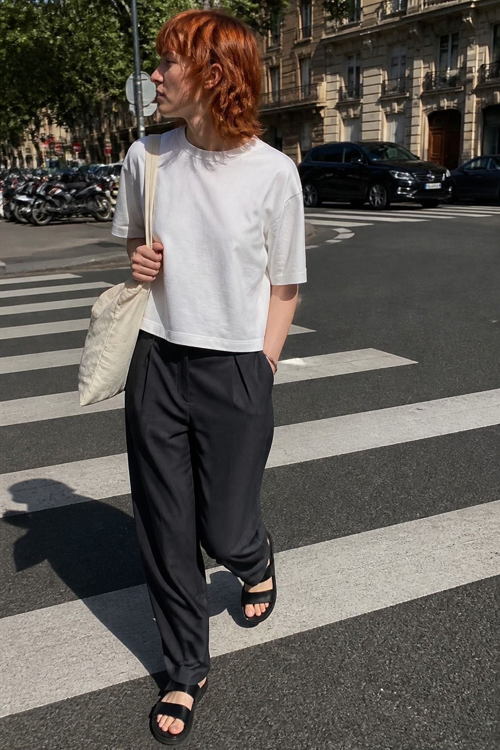 Woman wearing a boxy white T-shirt with relaxed trousers