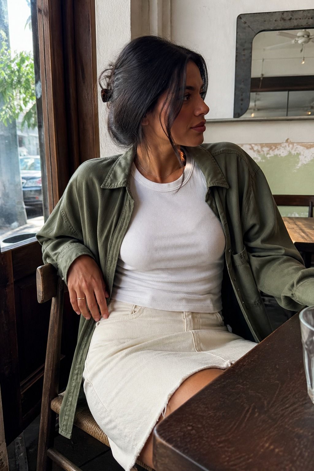 Woman wearing a ribbed white T-shirt with an olive overshirt
