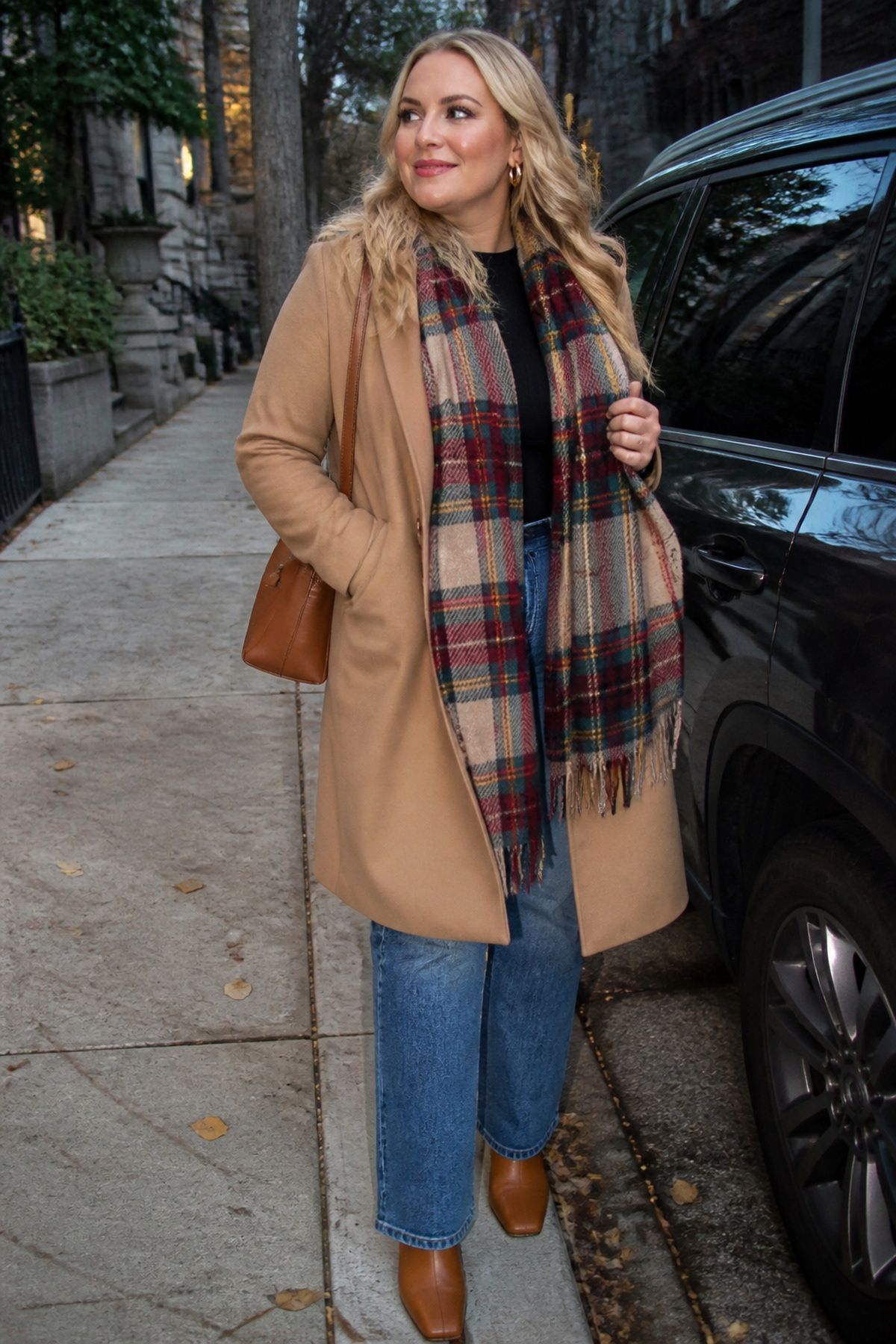 Woman wearing a tartan scarf with a camel coat, a casual Christmas Eve outfit