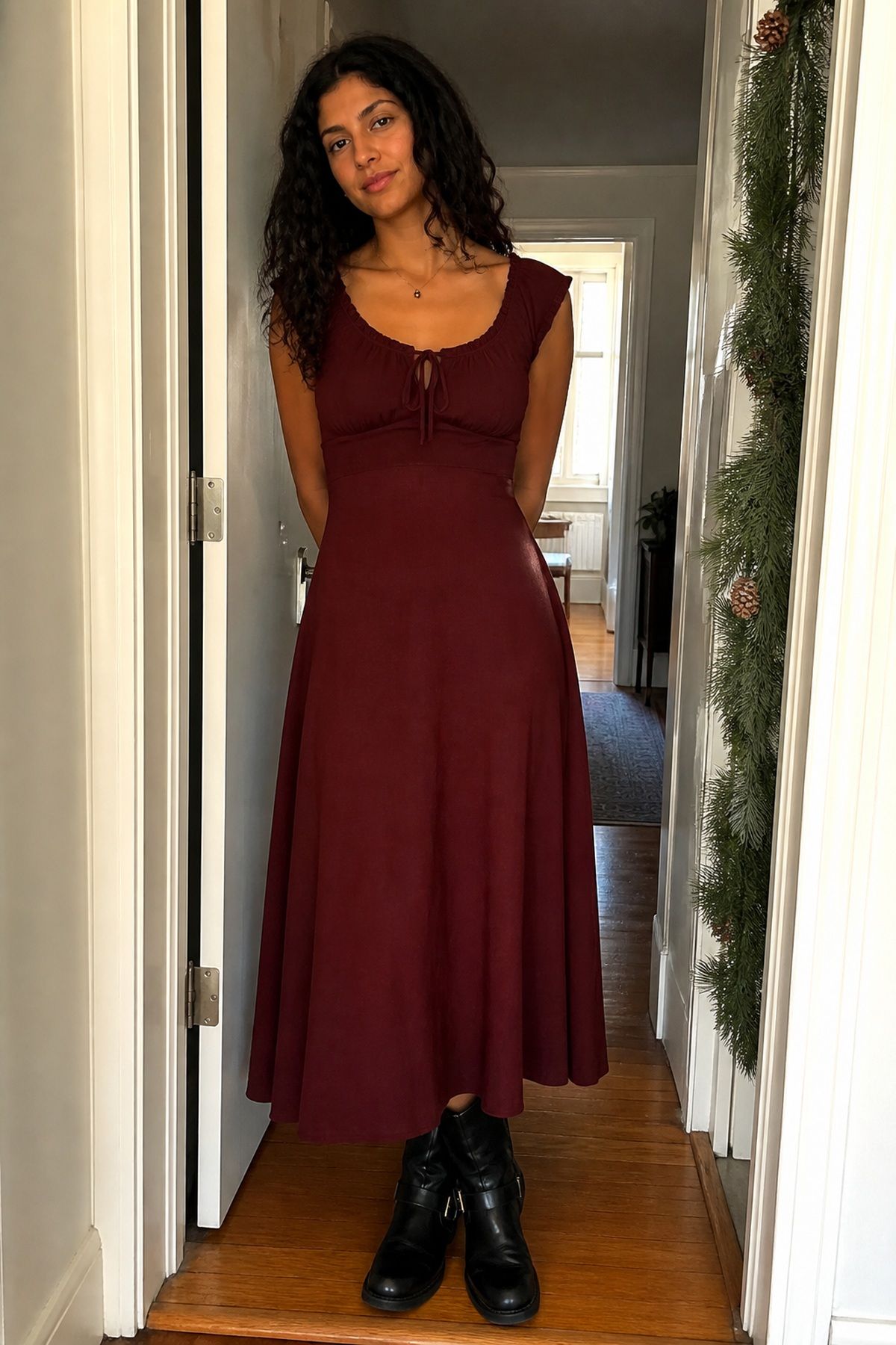 Woman wearing a burgundy dress with flat boots, a casual Christmas Eve outfit