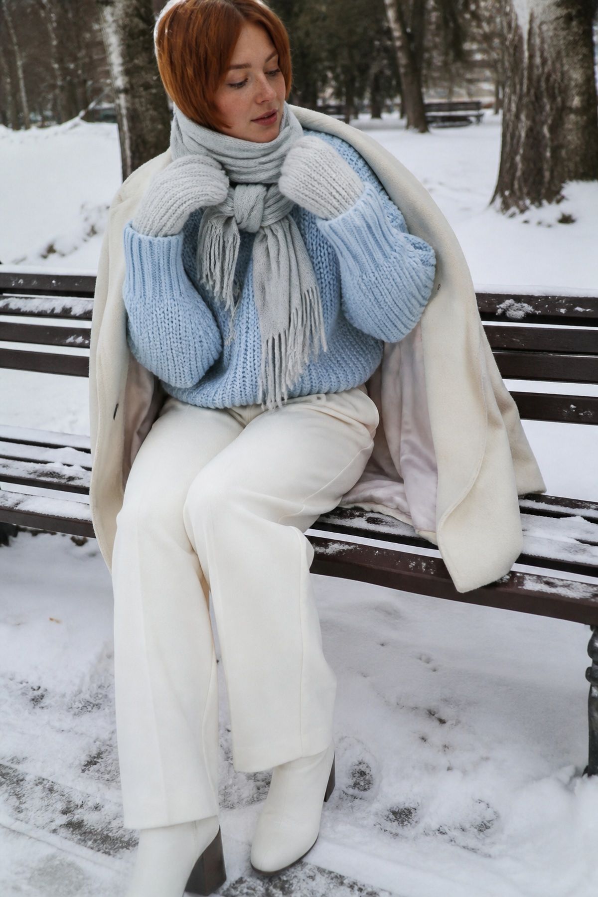 Woman wearing icy blue sweaters with winter whites, a winter family photo outfit